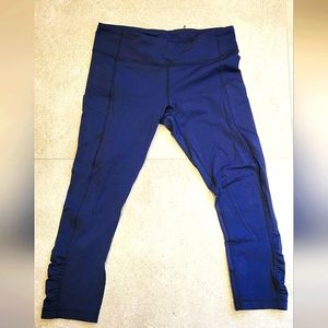 Lululemon navy blue cropped pants with side pockets and back storage pocket.